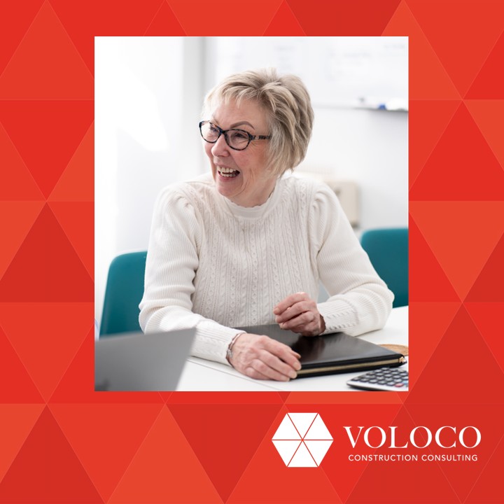 Photo of a woman smiling sat at a desk